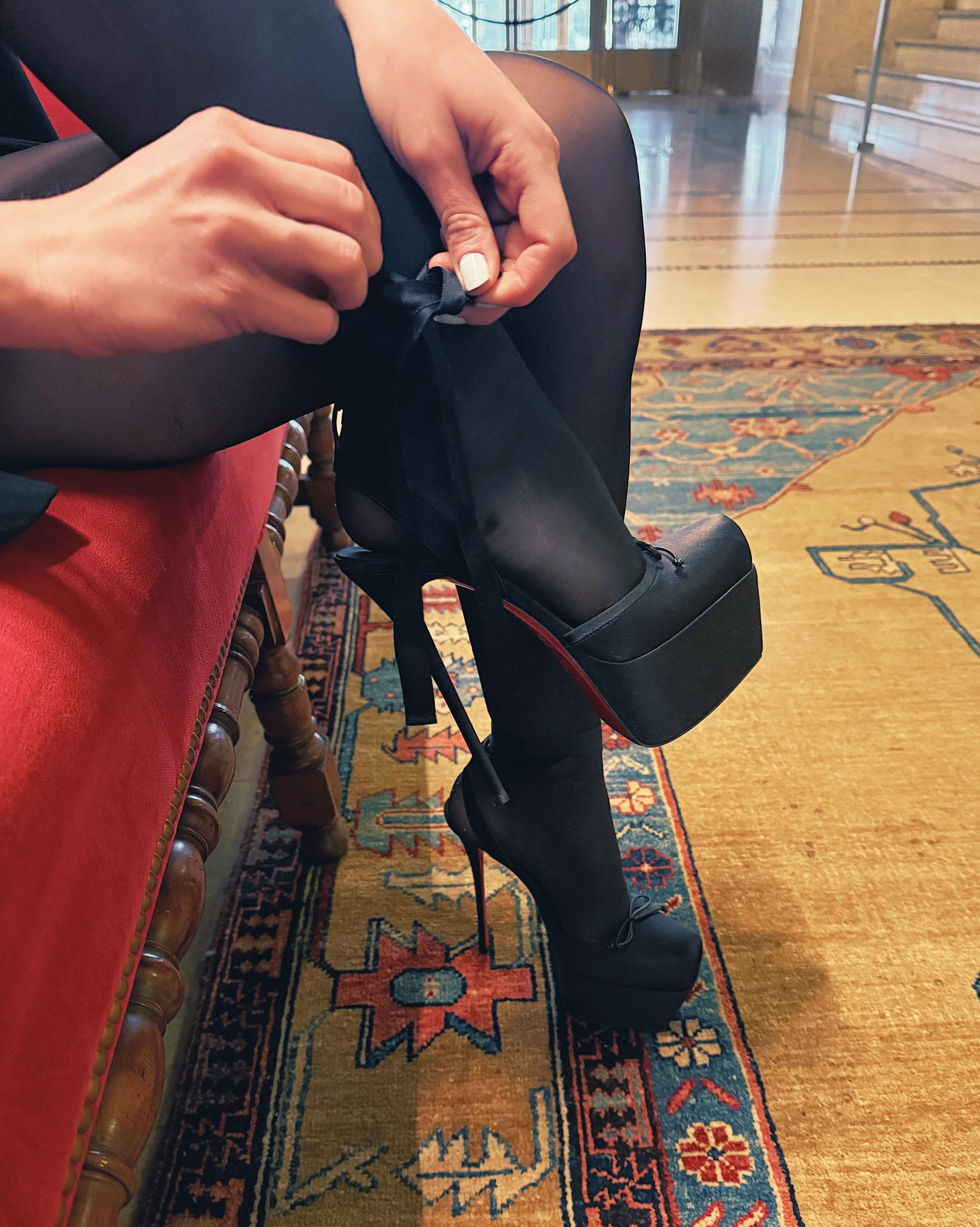 Detail of ballet-heel ribbon ties in a hotel lobby, photographed as a fashion still